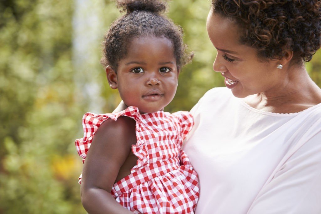 Portrait of African American mother holding baby daughter